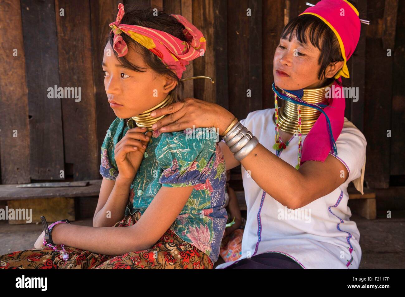Myanmar (Burma), Kayah state, Kayan tribe (Padaung), Dau Ki (Pan Pat group), Moe Da is putting bronze rings to Moe Sa Stock Photo