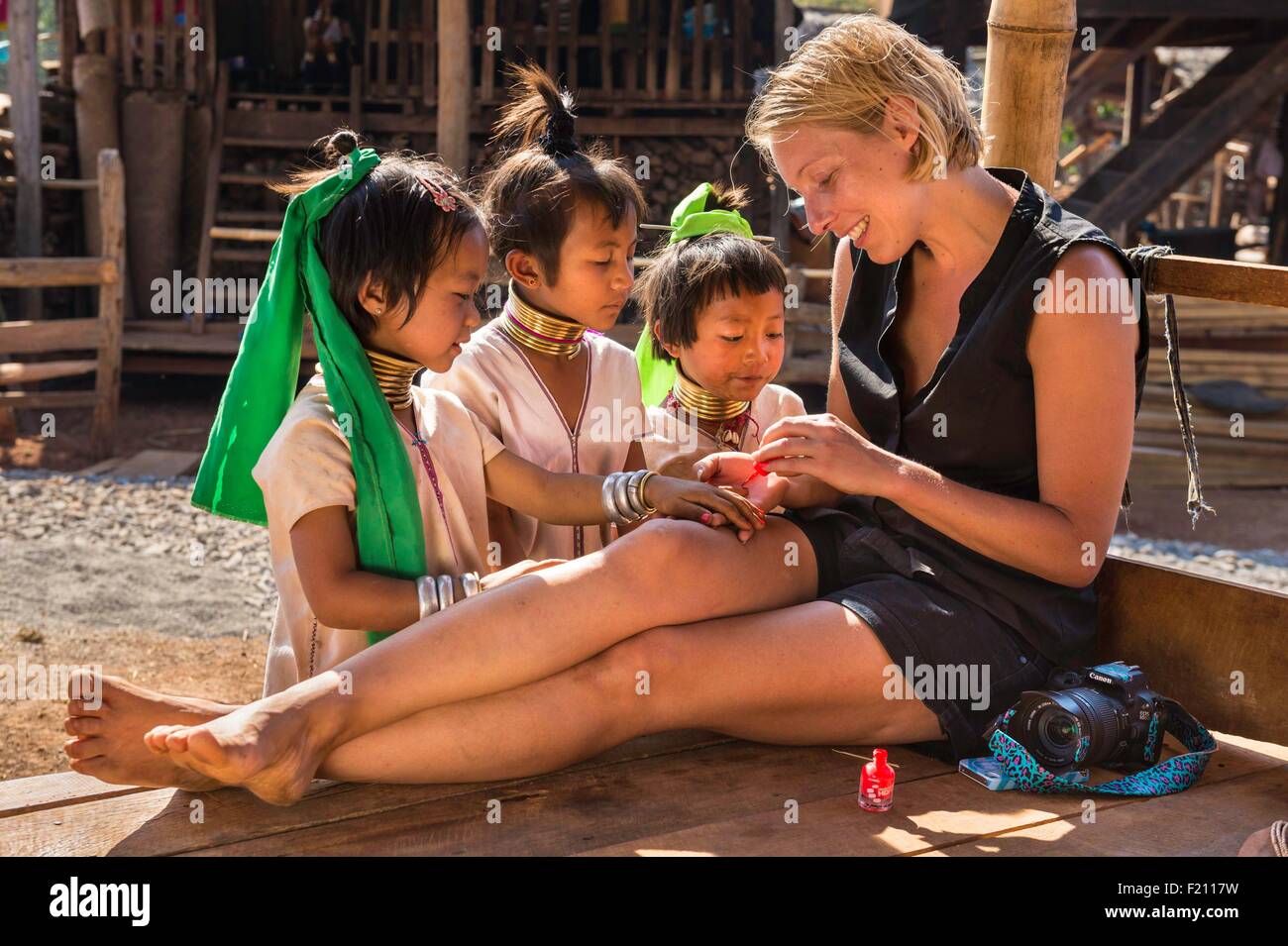 Myanmar (Burma), Kayah state, Kayan tribe (Padaung), Dau Ki (Pan Pat group), tourist putting nail painting to kids Stock Photo