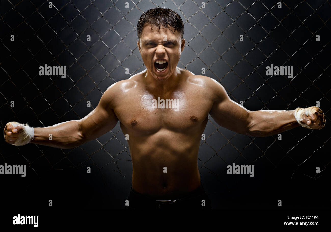 horizontal photo  muscular young  guy street-fighter,  aggression frightening  yell , hard light Stock Photo