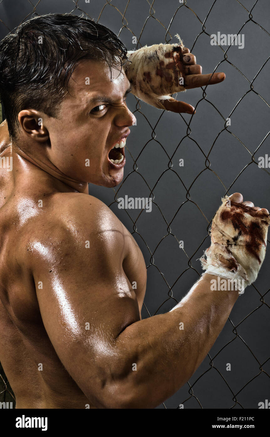 vertical photo  muscular young  guy street-fighter,  aggression awesome yell , hard light Stock Photo