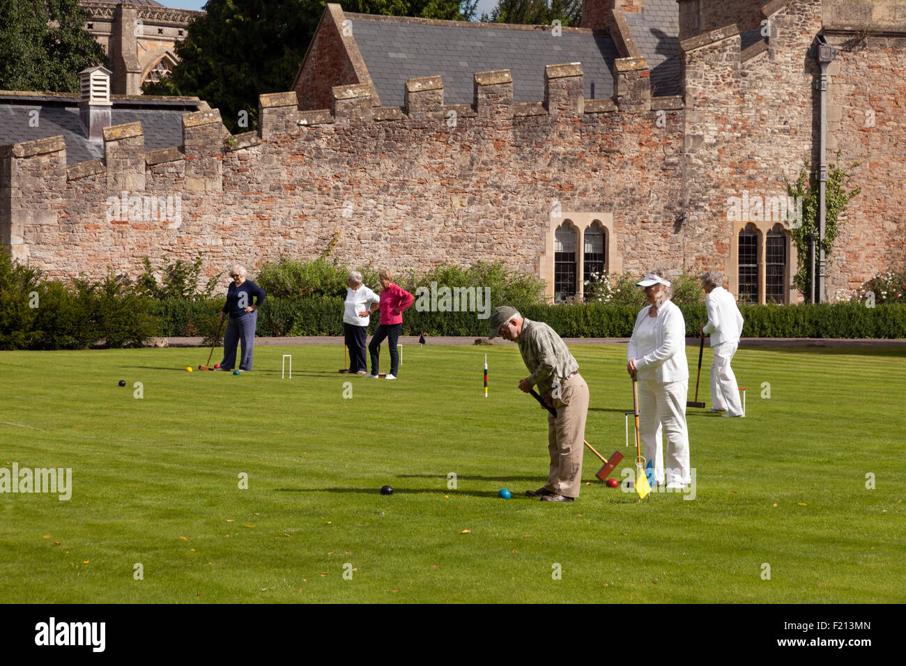 Elderly people playing croquet on the lawn,  the Bishop's Palace, Wells, Somerset UK Stock Photo
