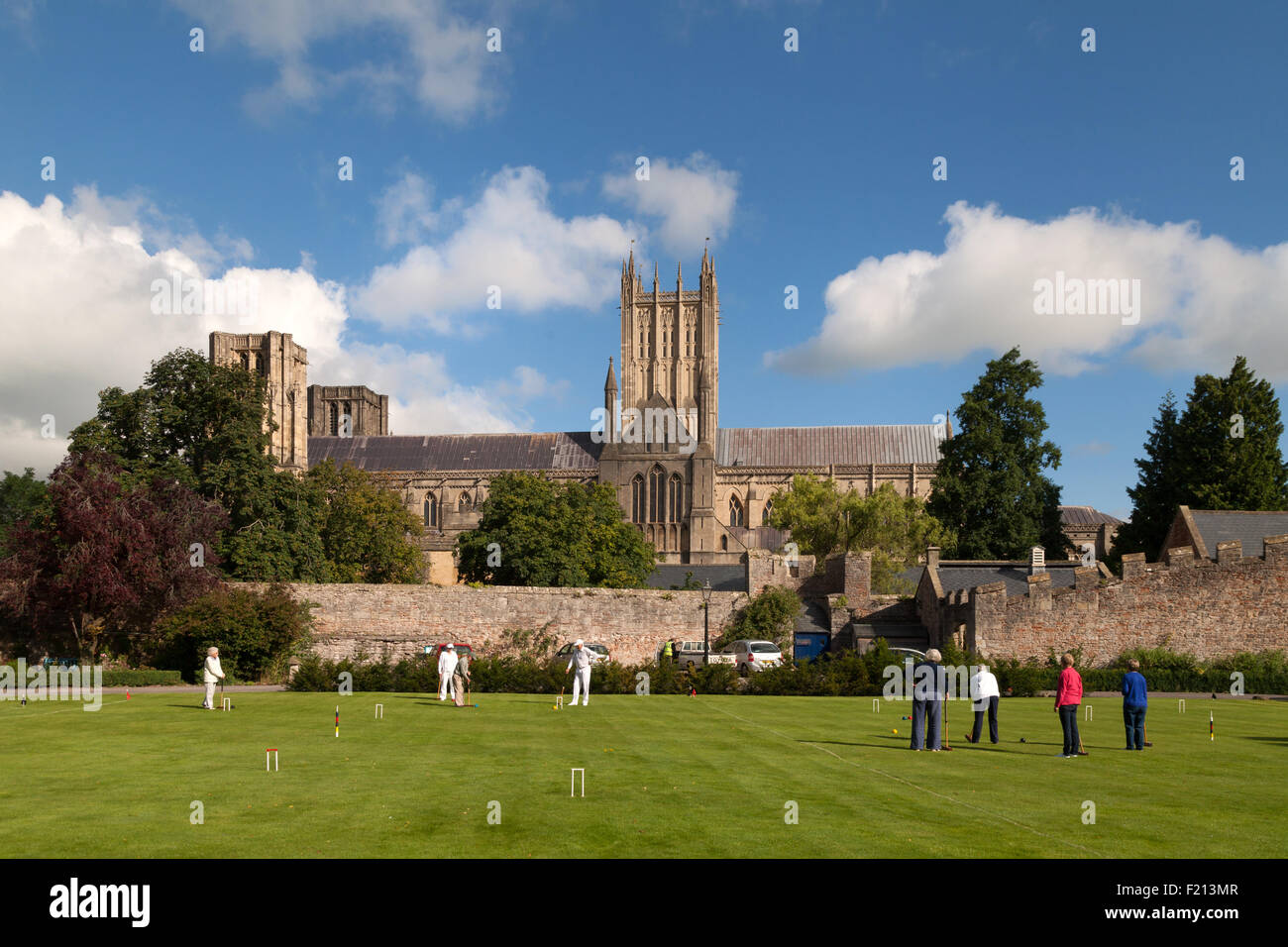 Traditional english scene; People playing croquet in front of the medieval 12th century Wells Cathedral, Wells, Somerset England UK Stock Photo