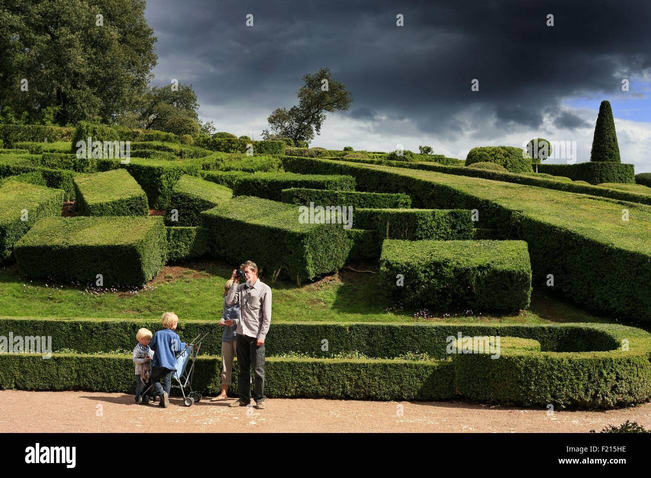 France, Dordogne, Perigord, Vezac, Marqueyssac castle, Family of tourists visiting the gardens of a castle under a stormy sky Stock Photo