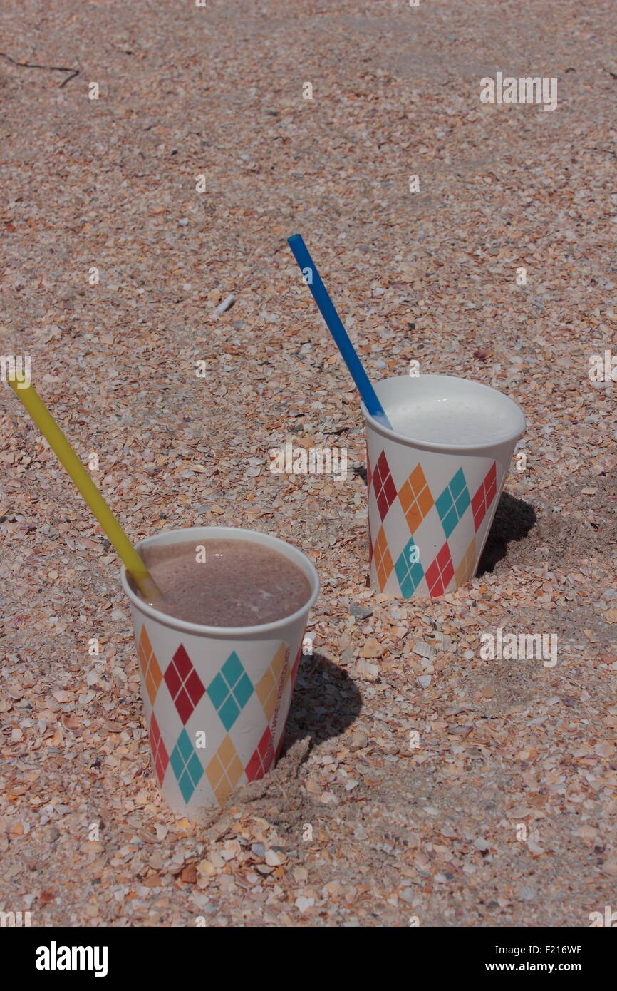 in the sand on the beach there are two cocktail paper cup Stock Photo ...