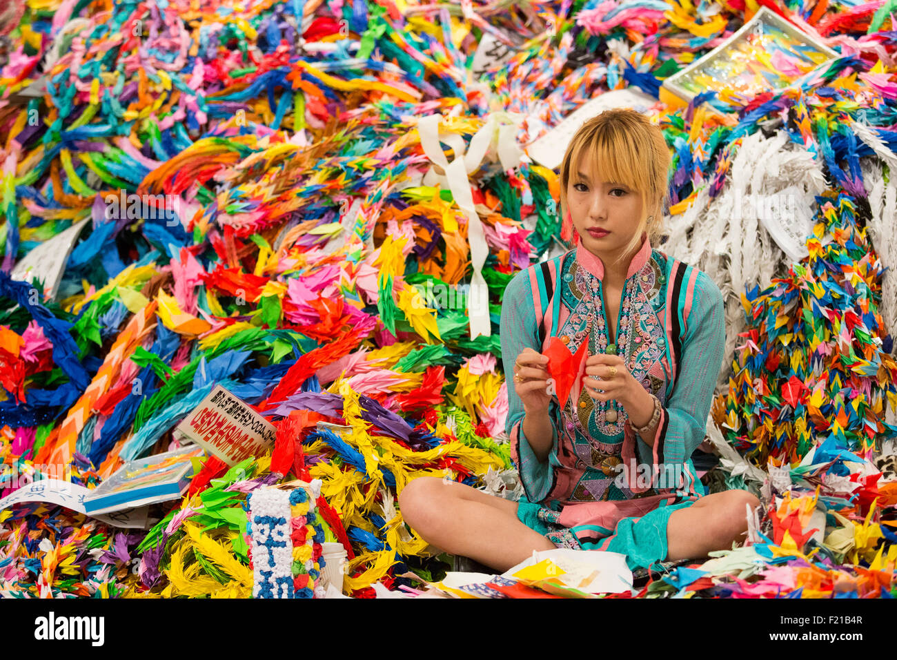 London, UK. 9 September 2015. Ellie from the Chim Pom artist collective from Tokyo unfolds origami birds and asks visitors to refold them. The finished origami birds will be sent to Hiroshima. Winners of the Emerging Artist of the Year at the Prudential Eye Awards. Press preview of the START Art Fair which returns to the Saatchi Gallery from 10 to 13 September 2015. START provides a platform for emerging artists and new art scenes from around the world and takes place across all three floors of the Saatchi Gallery. Photo: ukartpics/Alamy Live News Stock Photo