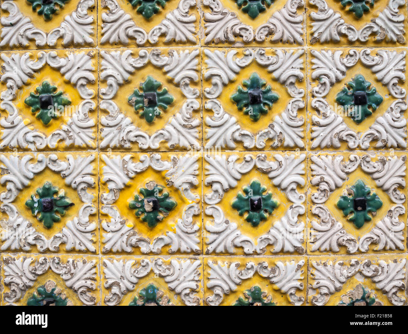Traditional tiles with relief in yellow, ahite and green Stock Photo