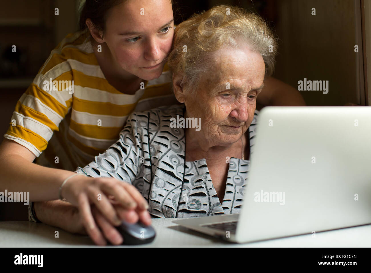 Young girl teaches her grandmother to work on the computer. Stock Photo