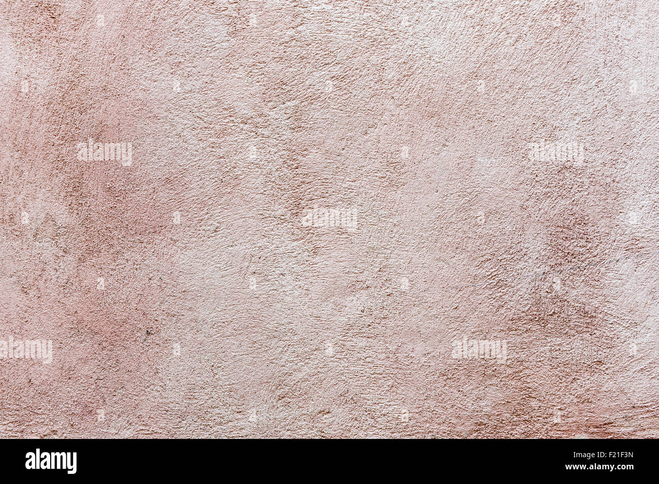 Old vintage plastered stucco wall brushed texture abstract background in faded pink color Stock Photo