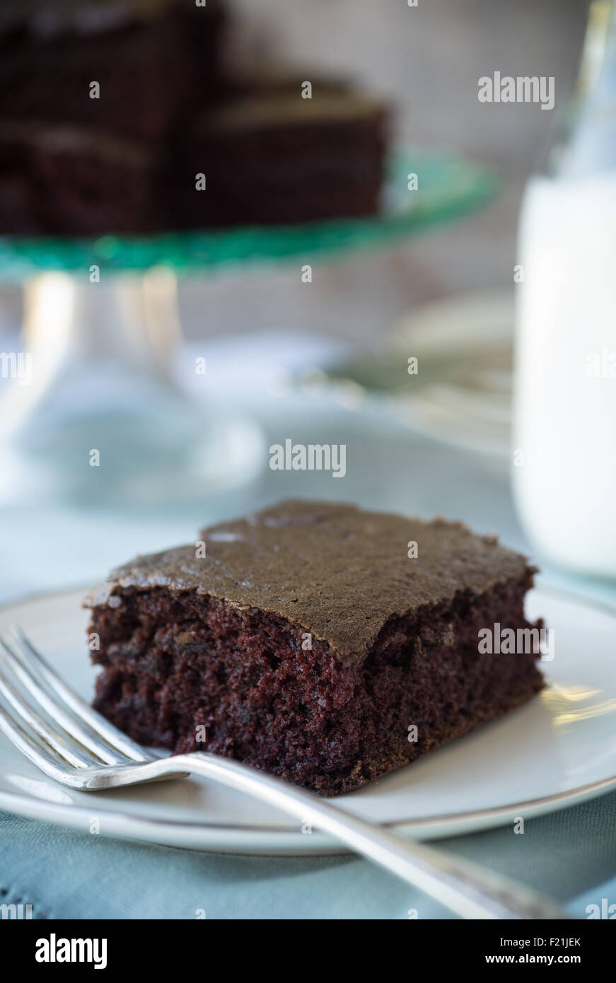 Super moist square of rich chocolate cake with milk Stock Photo