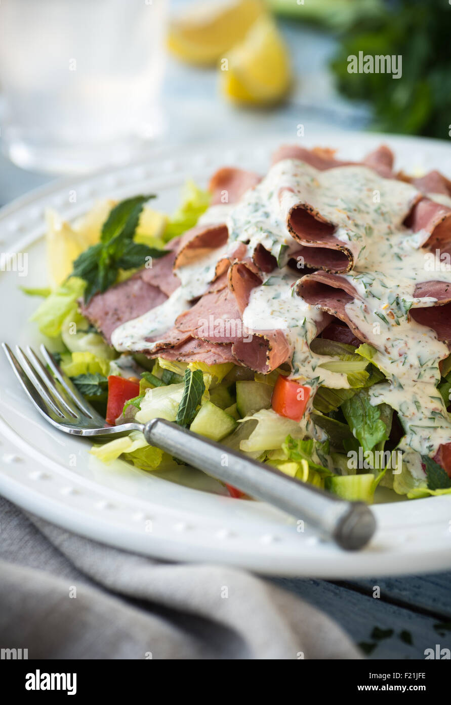 Peppery roast beef slices on a chopped salad with minty dressing Stock Photo