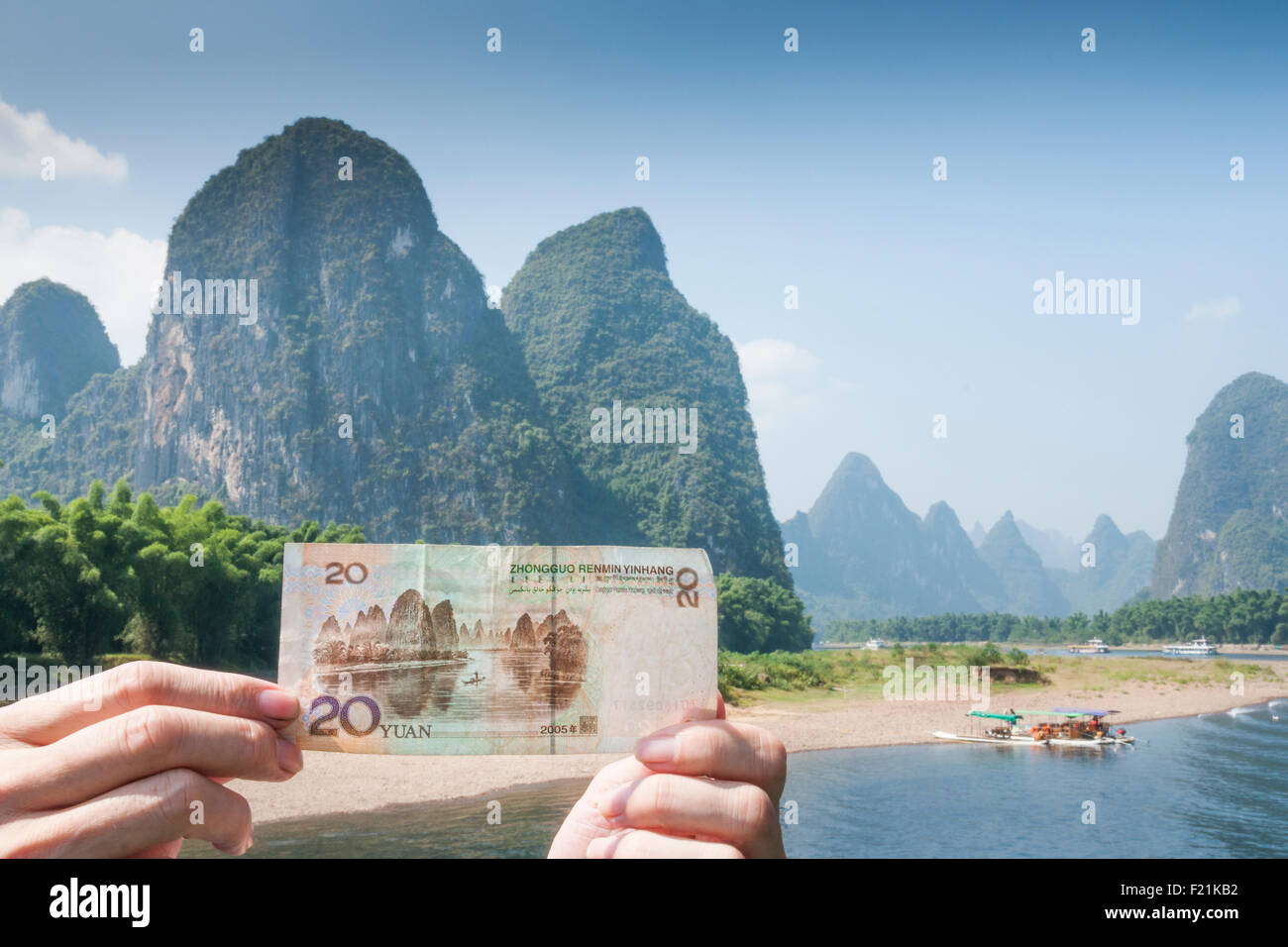 Hands hold a 20 Yuan bill in the location that inspired the painting featured on the money, Li River, Guilin, China, Asia Stock Photo