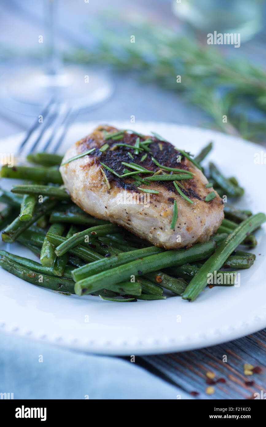 Sauteed pork chop with rosemary over spicy green beans Stock Photo Alamy