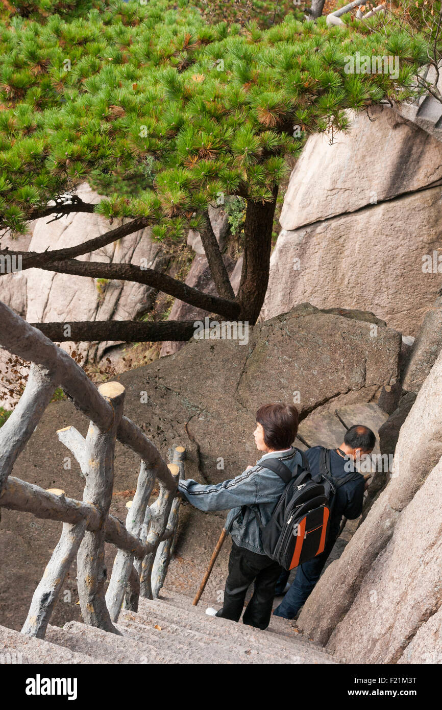 Mature Asian couple descend concrete steps on the Xihai Grand Canyon West Sea trail, Yellow Mountain, Huangshan, Anhui province, Stock Photo