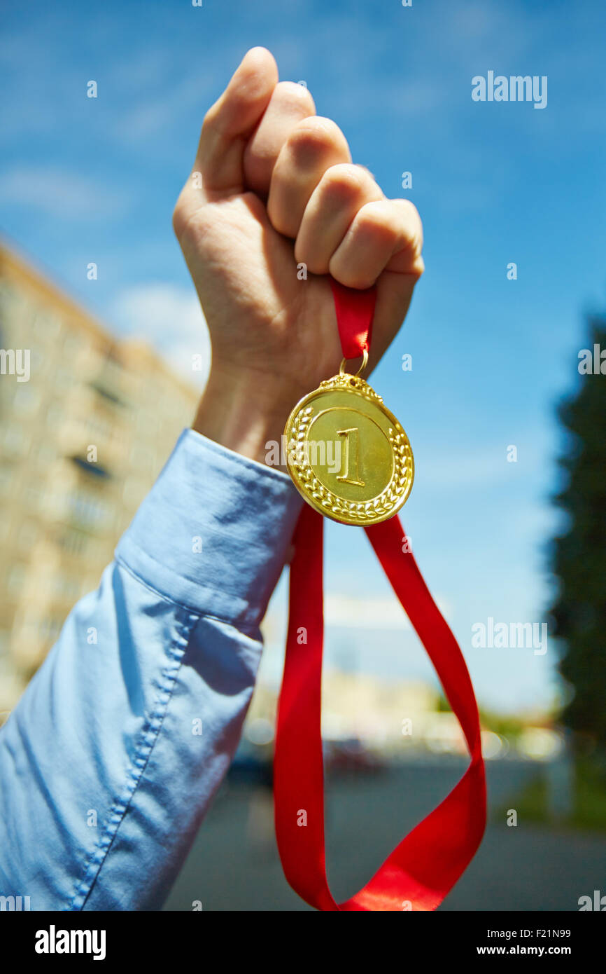 Hand of businessman with gold medal on red ribbon Stock Photo - Alamy