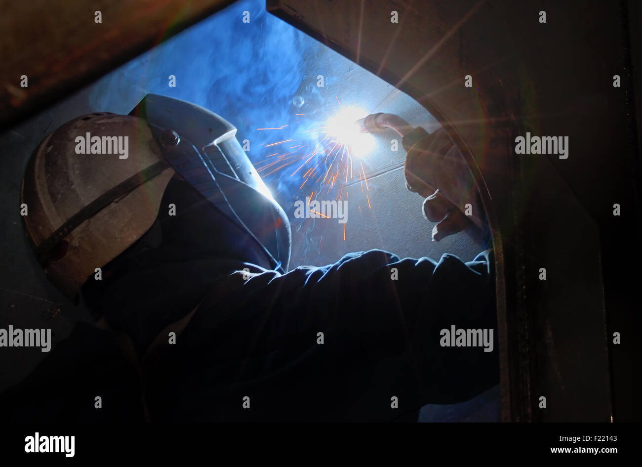 MIG welder uses torch inside of ship Stock Photo