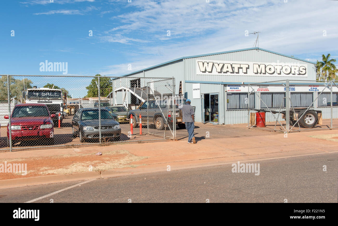 Indigenous man looking at cars of a car repair workshop and garage at Tennant Creek, Northern Territory, Australia Stock Photo