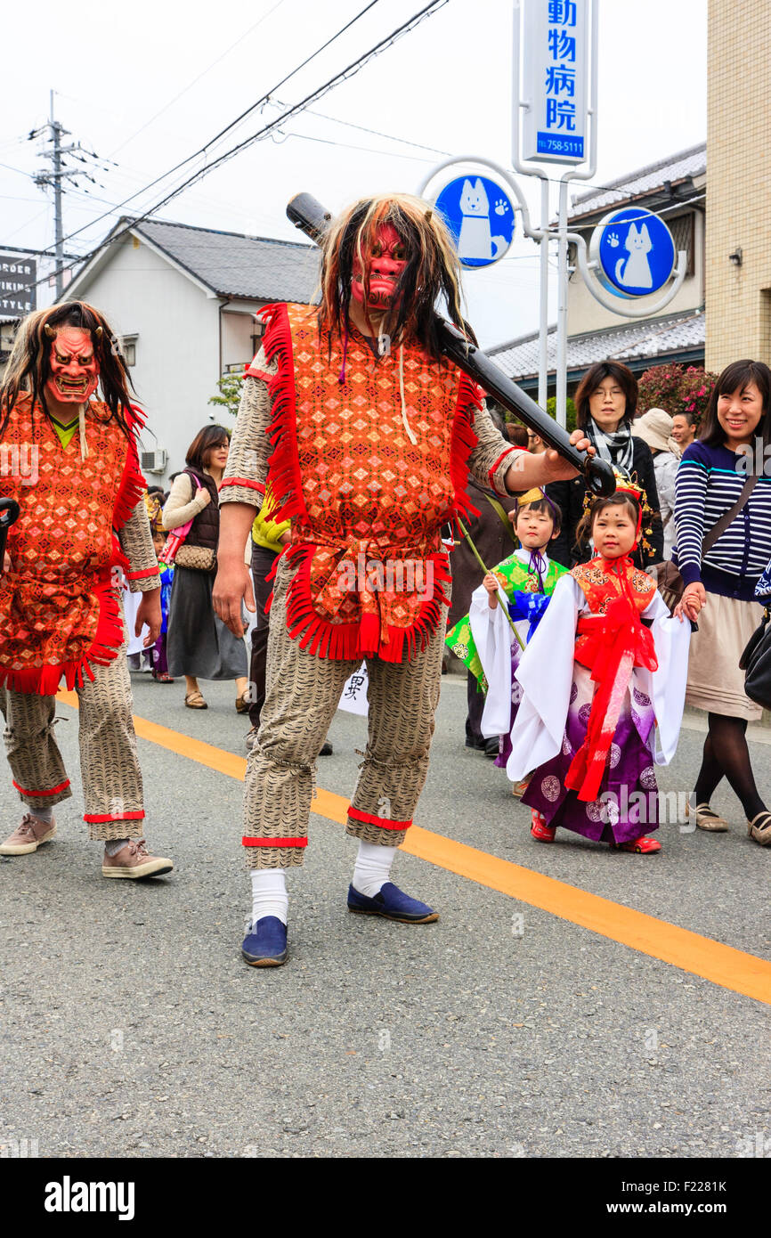 Genji Festival parade in Japan. Man dressed as a Shishimai or Namahage type demon. Wears red costume and horrific face mask with unkempt hair. Stock Photo