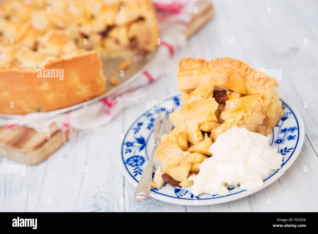 Homemade Dutch apple pie with whipped cream on a rustic table. Stock Photo