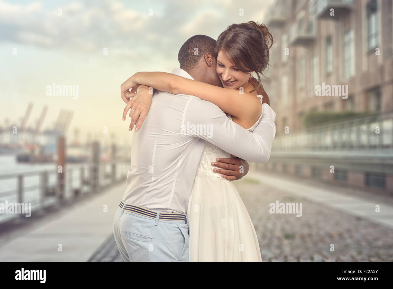 Happy romantic young couple share a special tender moment hugging each other as they show their love and affection, side view th Stock Photo