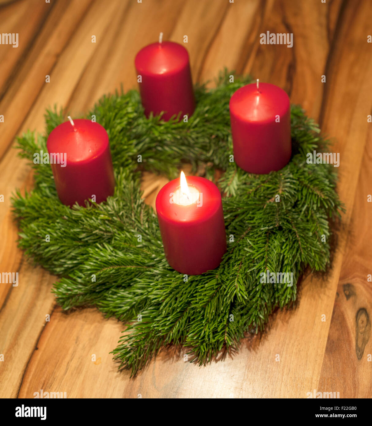 Adventskranz mit einer leuchtenden Kerze Stock Photo - Alamy