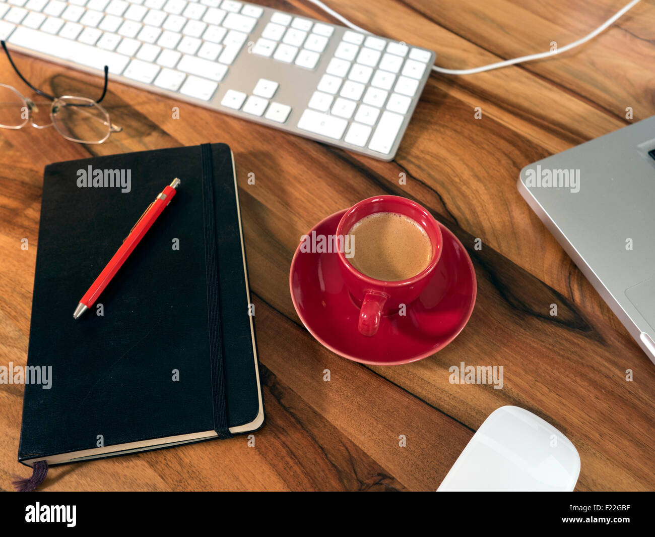 Tasse Kaffee mit Notizbuch, Tastatur, Computer und Maus Stock Photo
