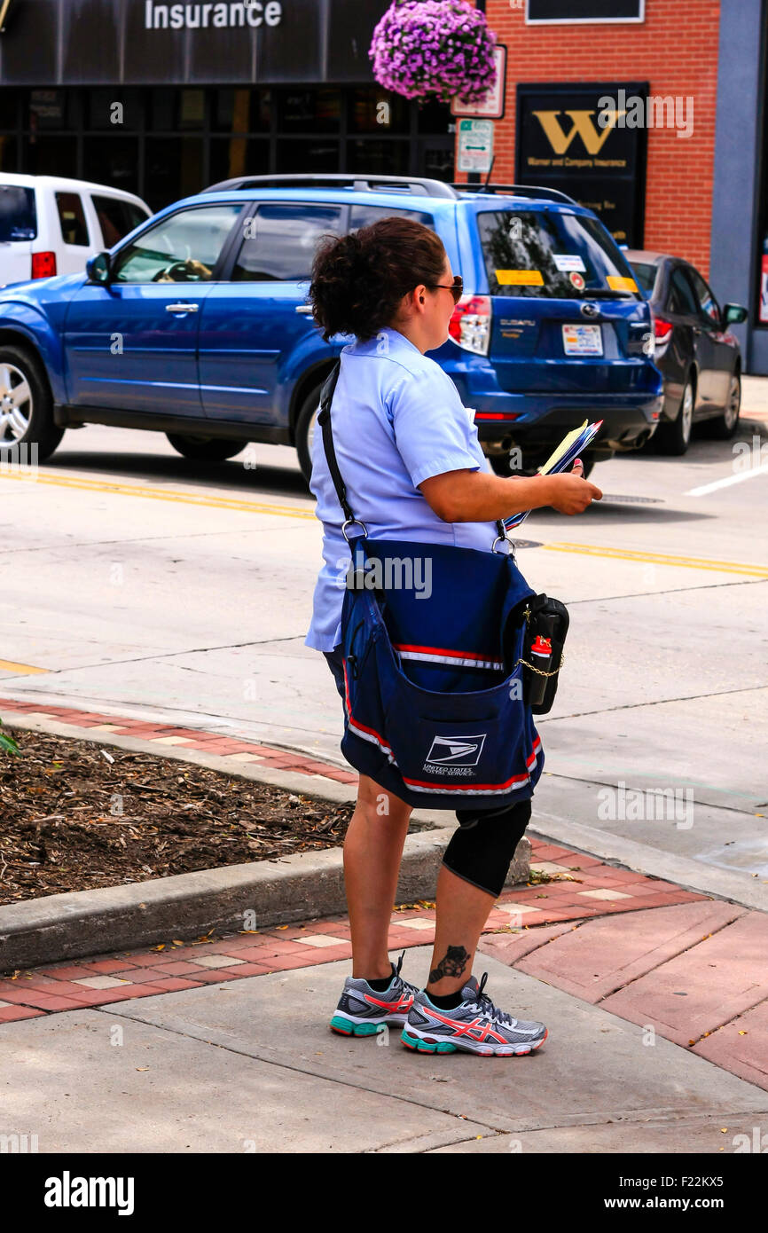 Female mail carrier walks her route in sneakers and a knee brace Stock