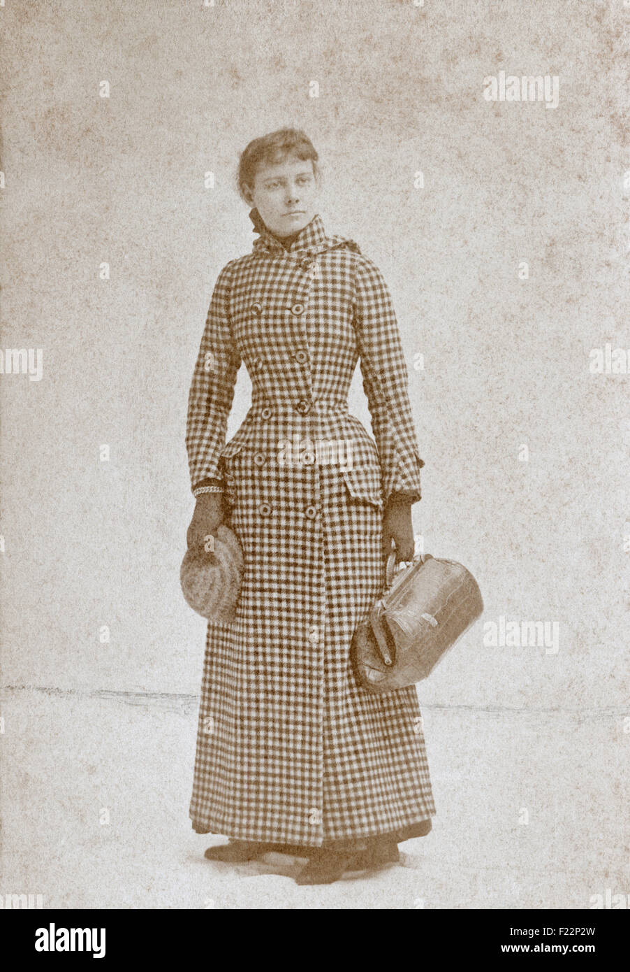 Antique 1890 cabinet card photograph of Nellie Bly, wearing her around-the-world voyage outfit, by Myers of New York. Nellie Bly (1864-1922) was the pen name of American journalist Elizabeth Cochrane Seaman. She was also a writer, industrialist, inventor, and a charity worker who was widely known for her record-breaking trip around the world in 72 days, and an exposé in which she faked insanity to study a mental institution from within. She was a pioneer in her field, and launched a new kind of investigative journalism. Stock Photo