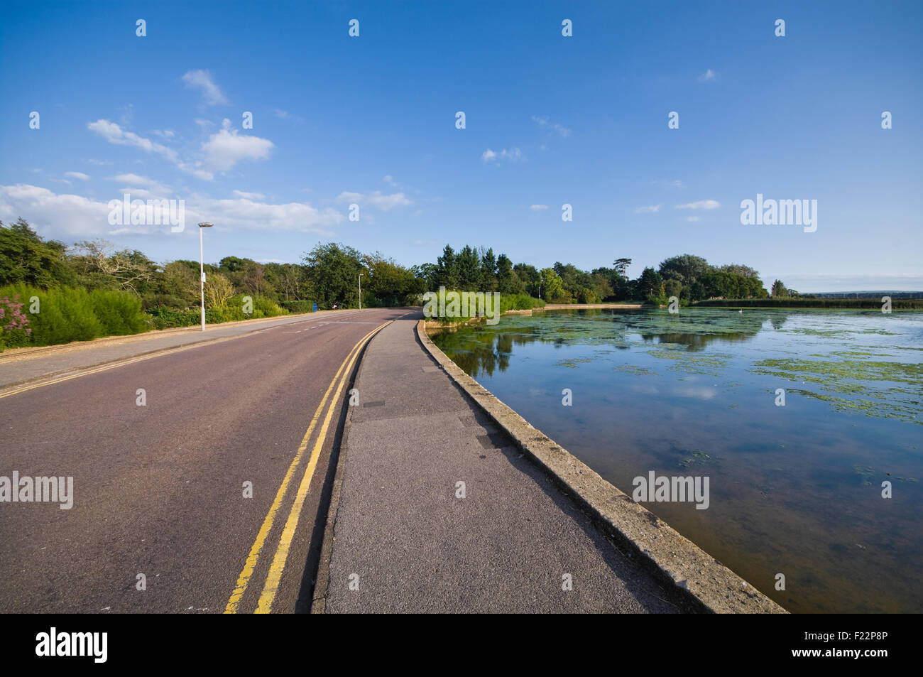 A road curves alongside the lake in Poole Park Stock Photo Alamy