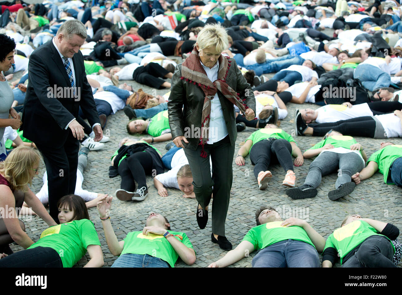 Berlin, Germany. 10th Sep, 2015. German Health Minister Hermann Groehe (L, CDU) and Green politician Renate Kuenast help up young people who have been lying on the ground as part of the '600 Lives' campaign in front of the Brandenburg Gate in Berlin, Germany, 10 September 2015. The campaign is part of World Suicide Prevention Day. The number 600 represents the 600 young people who commit suicide each year in Germany. Credit:  dpa picture alliance/Alamy Live News Stock Photo