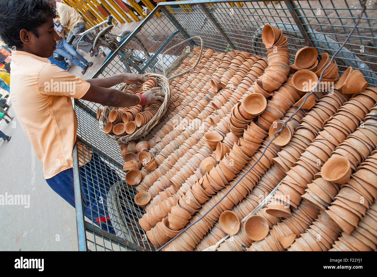 A teenage boy loads bicycle-drawn cart with clay cups (used for tea) Stock Photo