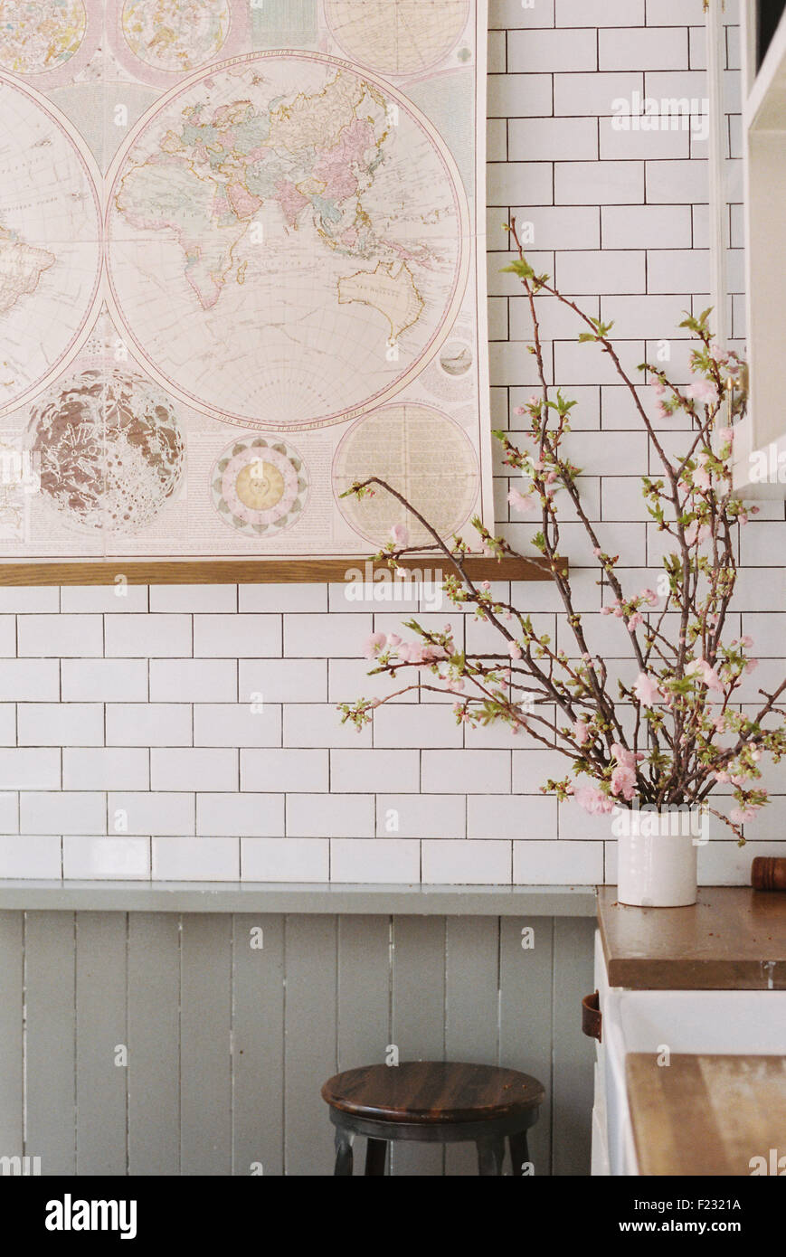 A kitchen worksurface, vase of flowers and a tiled wall. Stock Photo