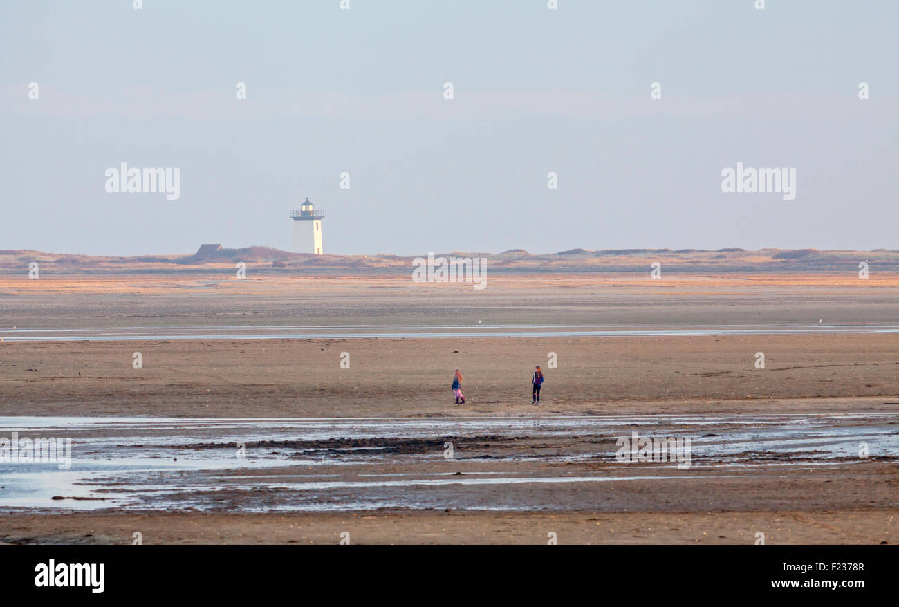 A lighthouse on the beach and people walking Stock Photo - Alamy
