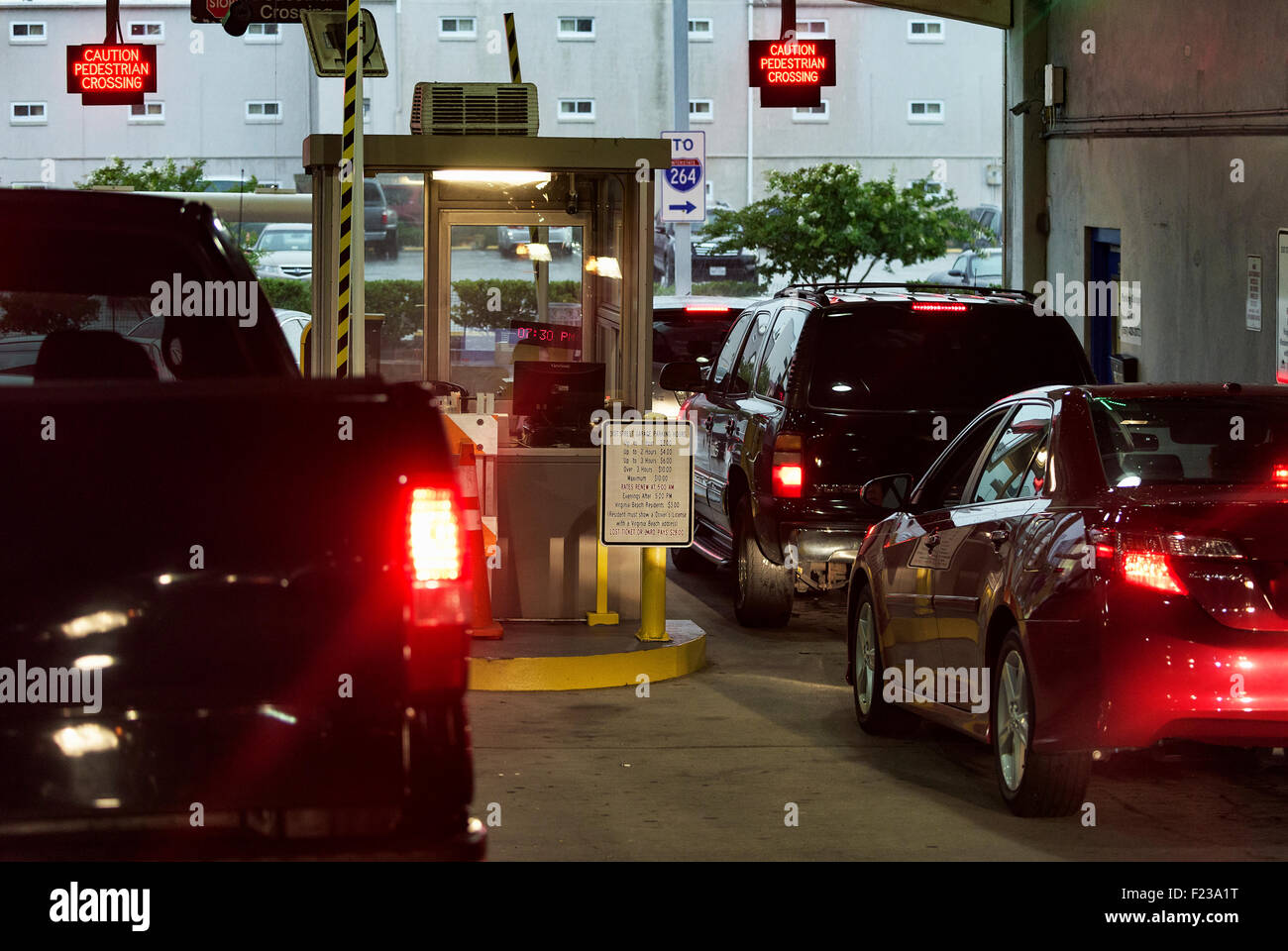 Cars wait to pay fee at a parking garage exit. Stock Photo