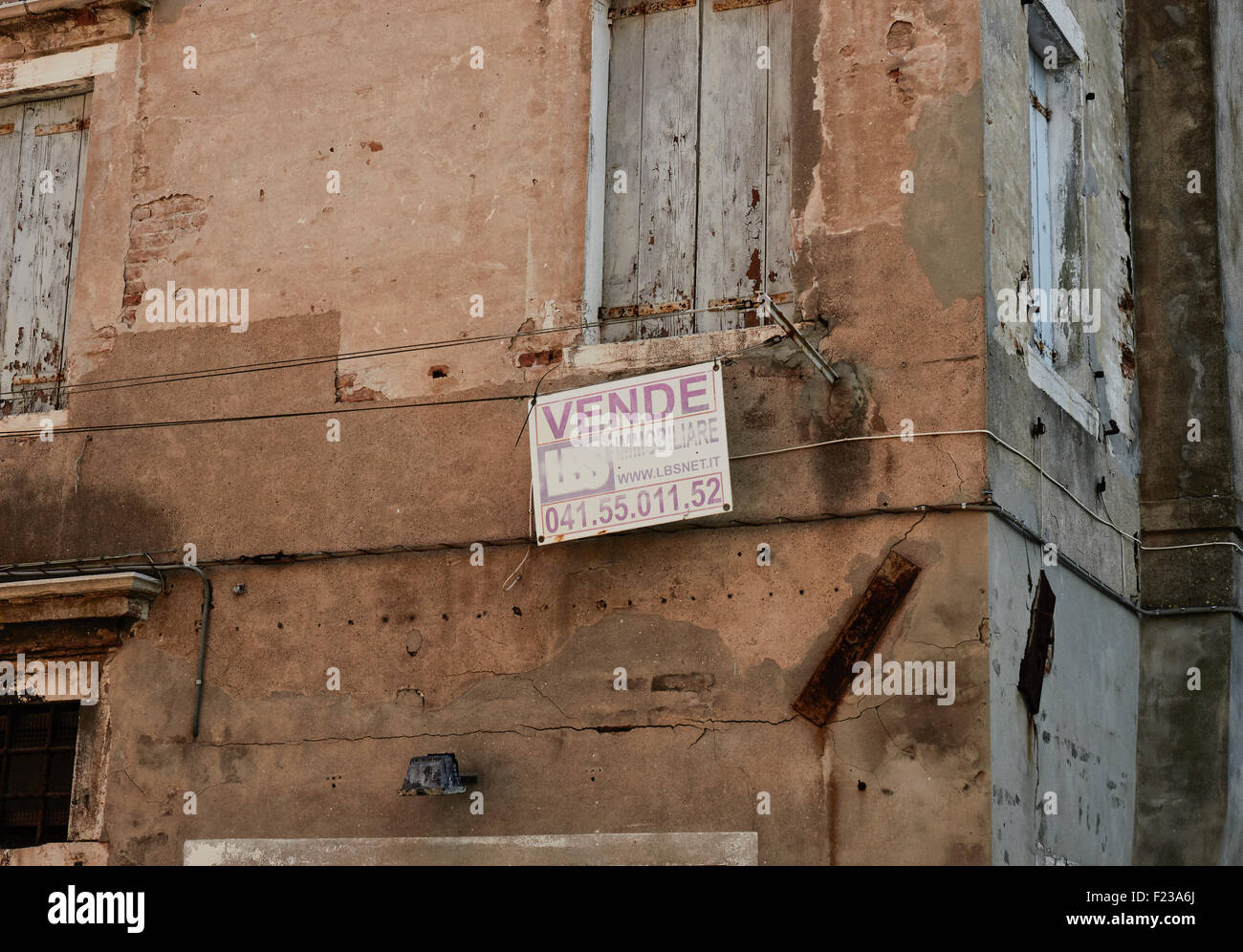 Old crumbling weathered shuttered house for sale Chioggia Venetian Lagoon Veneto Italy Europe Stock Photo