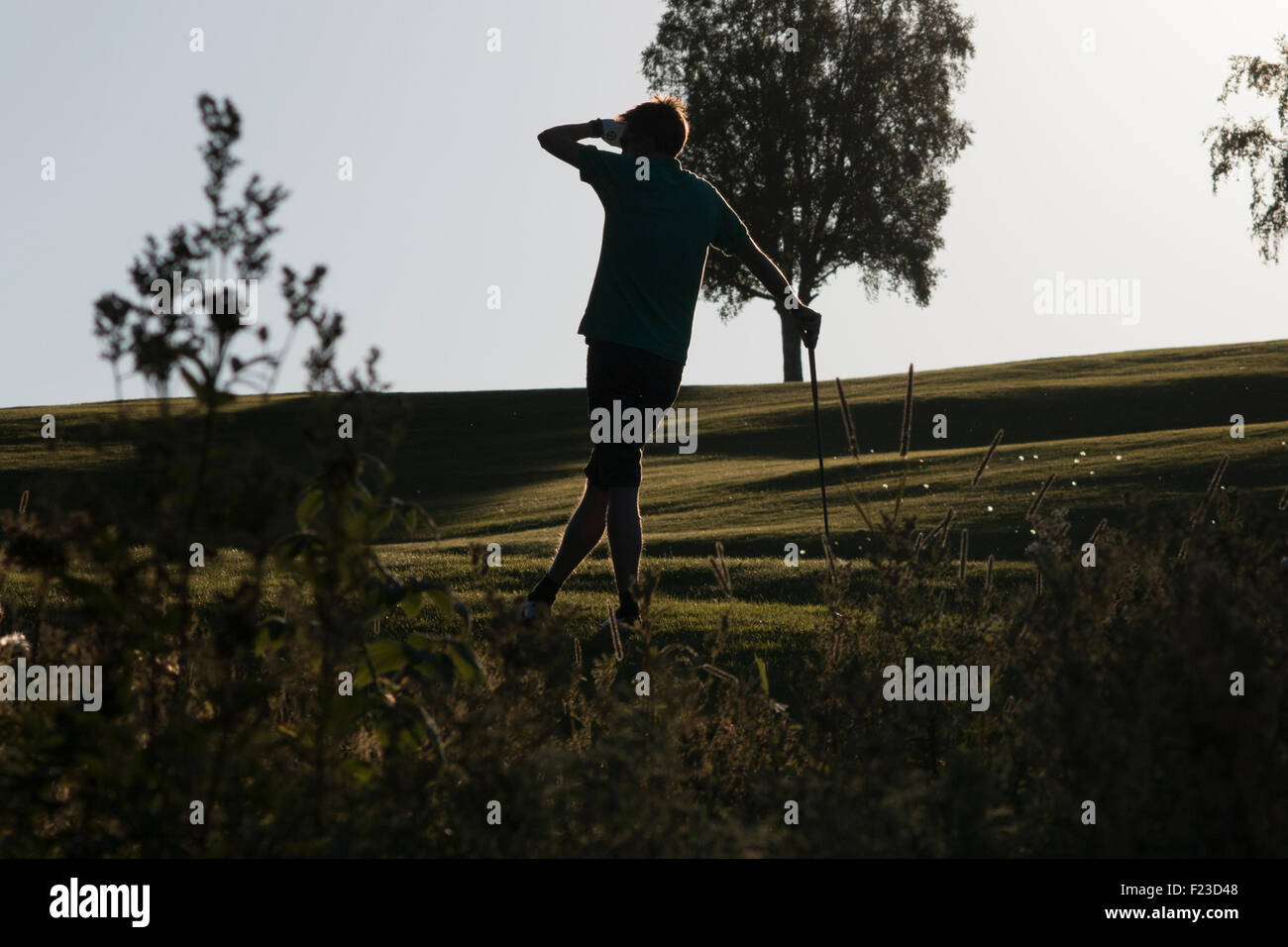 Golfer in evening sun on golf course Stock Photo