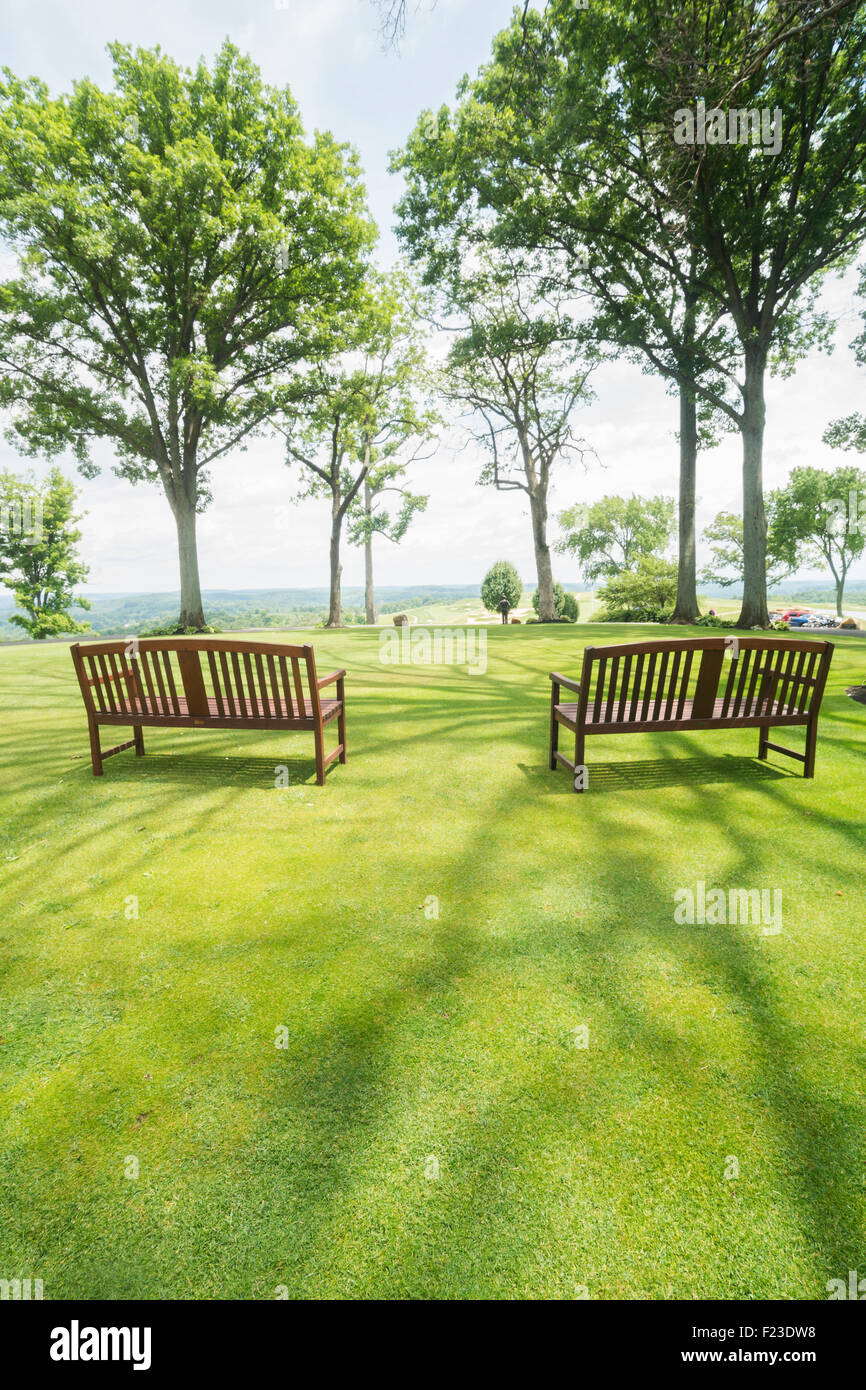 Two benches on the grassy lawn at the Pete Dye golf course, French Lick, Indiana, USA Stock Photo