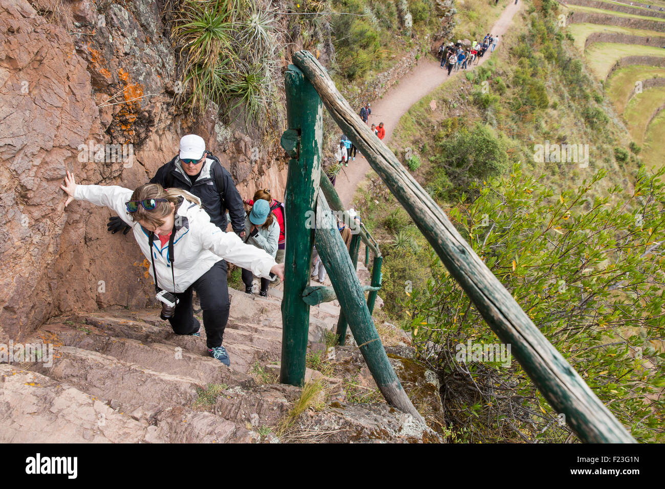 Peru, Calca Province, Tourists struggle up steep stairway at Inca Pisac ruins in Sacred Valley Stock Photo