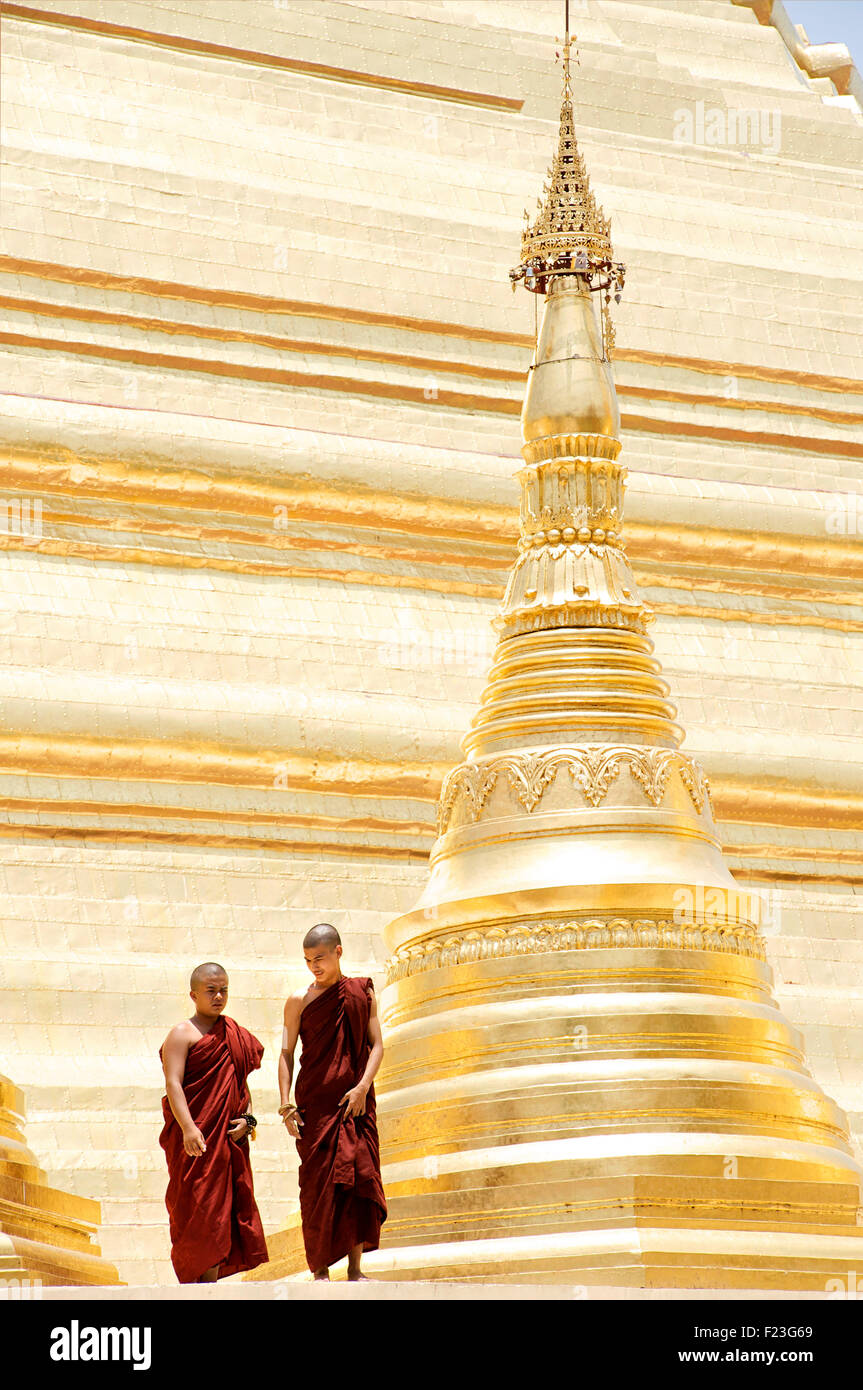 Monks standing beside stupa of Shwedagon Pagoda, Rangoon, Burma Stock Photo