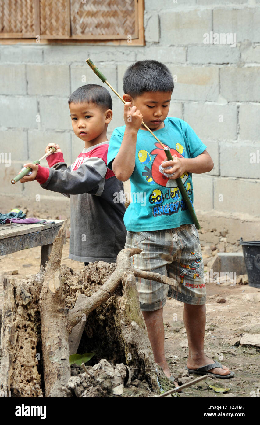 Lao boys with handmade 'spud' guns using bamboo and wet tissue. Luang Prabang, Laos. Stock Photo