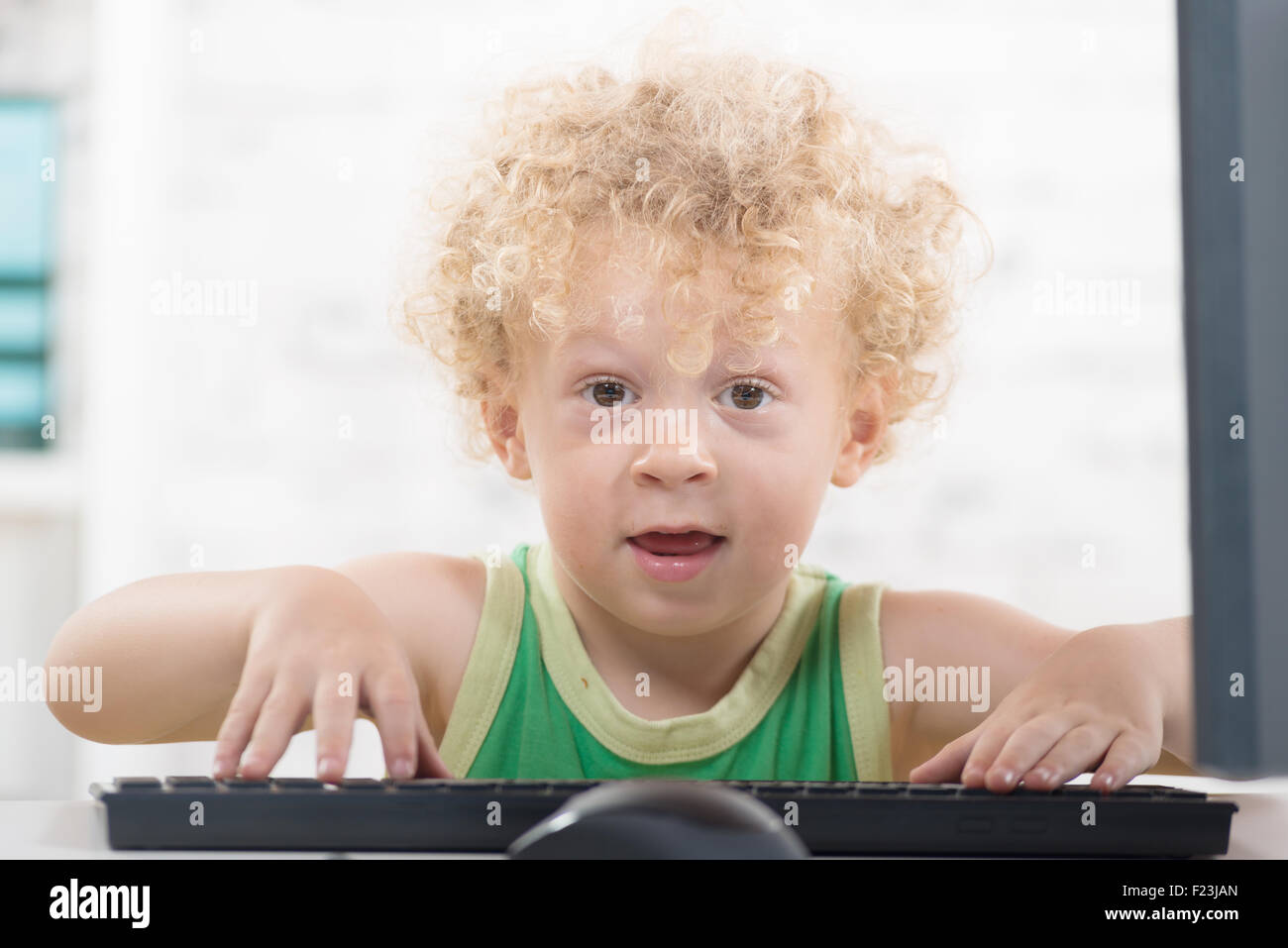 a little blond boy plays with a computer Stock Photo - Alamy