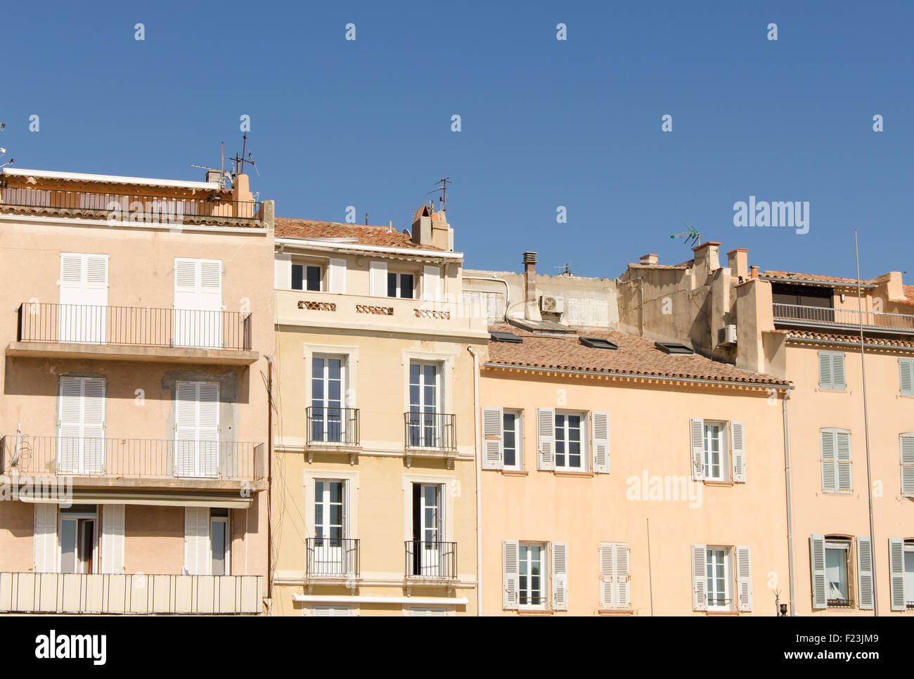 Frontage of beige buildings with a blue sky at Saint Tropez Stock Photo