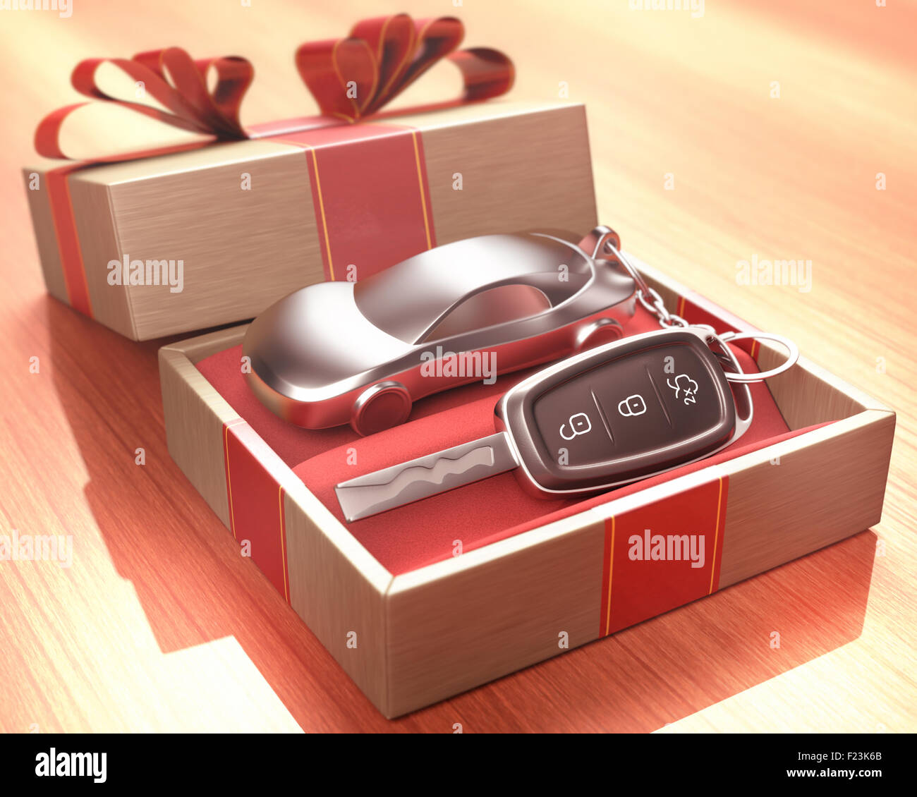 Car key inside a gift box with a red ribbon tied up on the cover. Depth of field with focus on the key button. Stock Photo