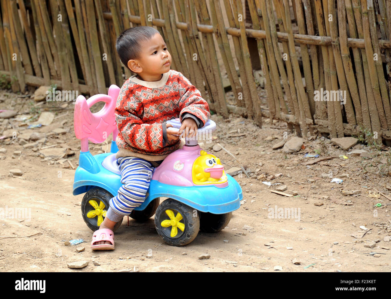 Boy on a plastic toy car, Luang Prabang, Laos Stock Photo