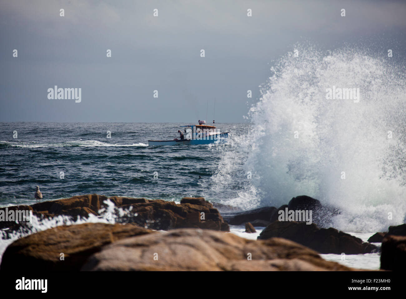 Lobster Boat coming back into Cape Porpoise Harbor with heavy seas crashing along the rocky