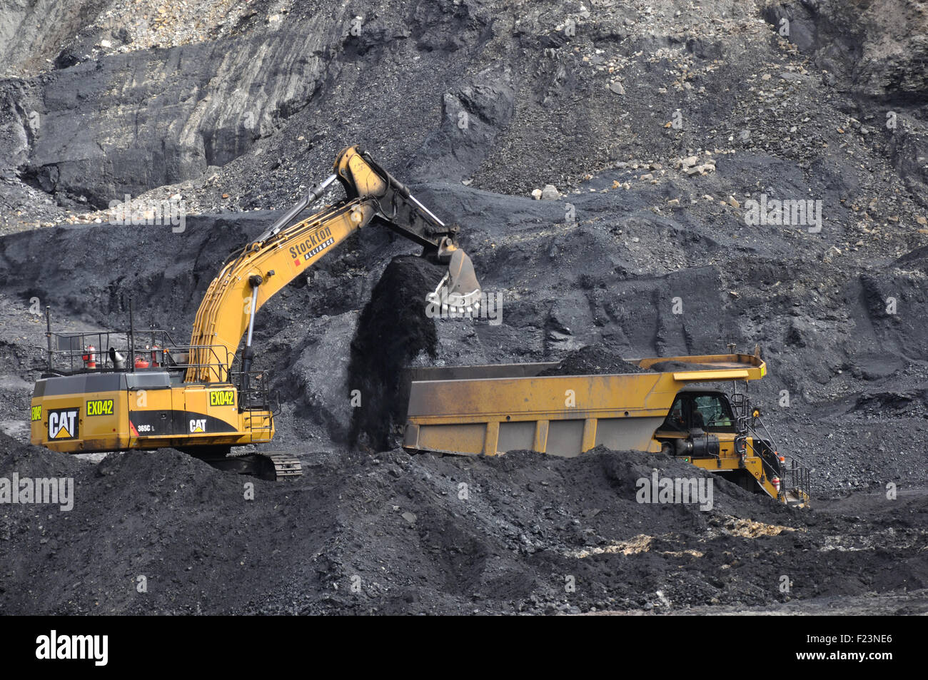 WESTPORT, NEW ZEALAND,AUGUST 31, 2013: A 40 ton digger loads coal into a truck at Stockton open cast coal mine Stock Photo
