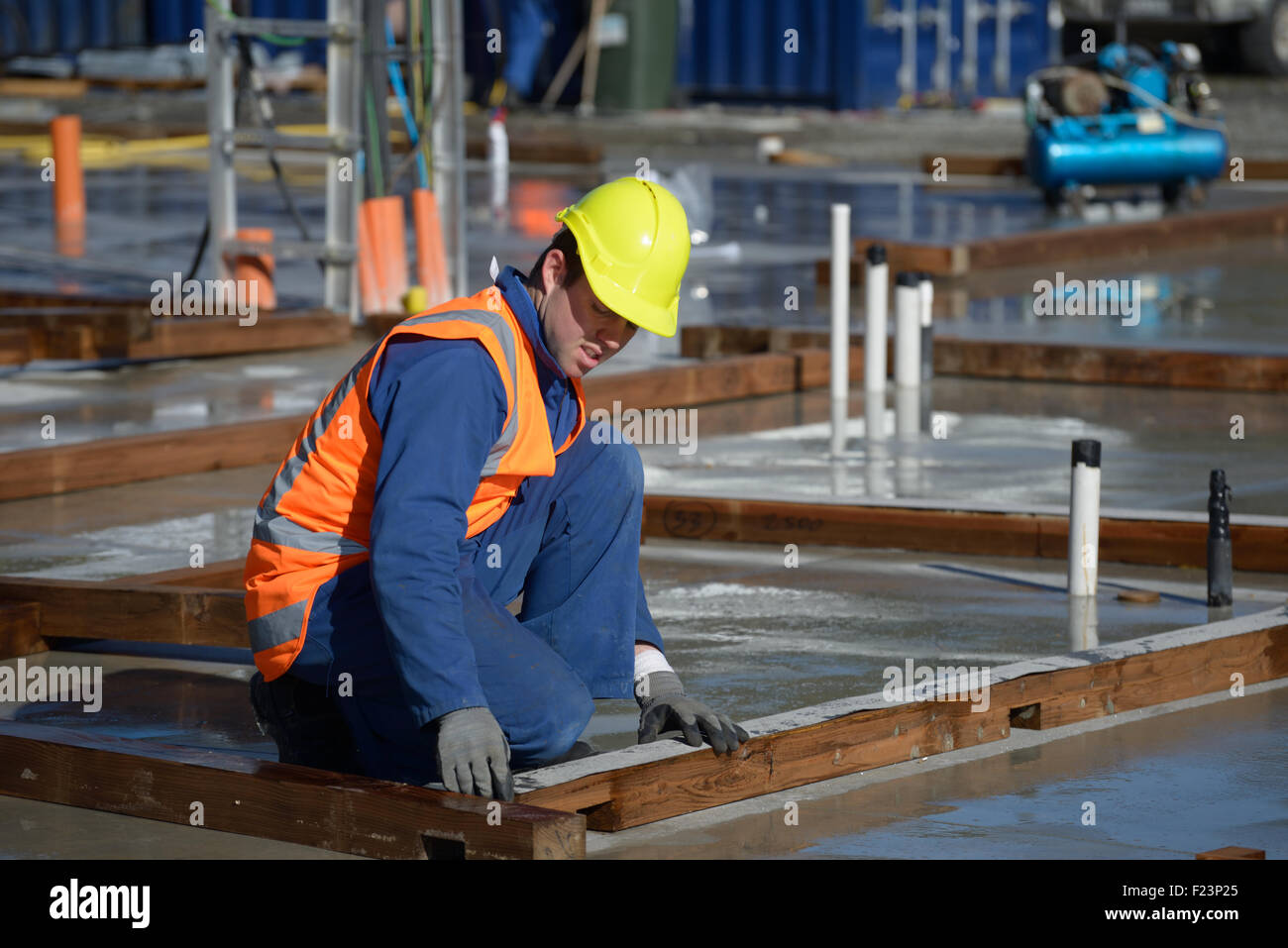 A builder places damp course on the base boards for a large building Stock Photo