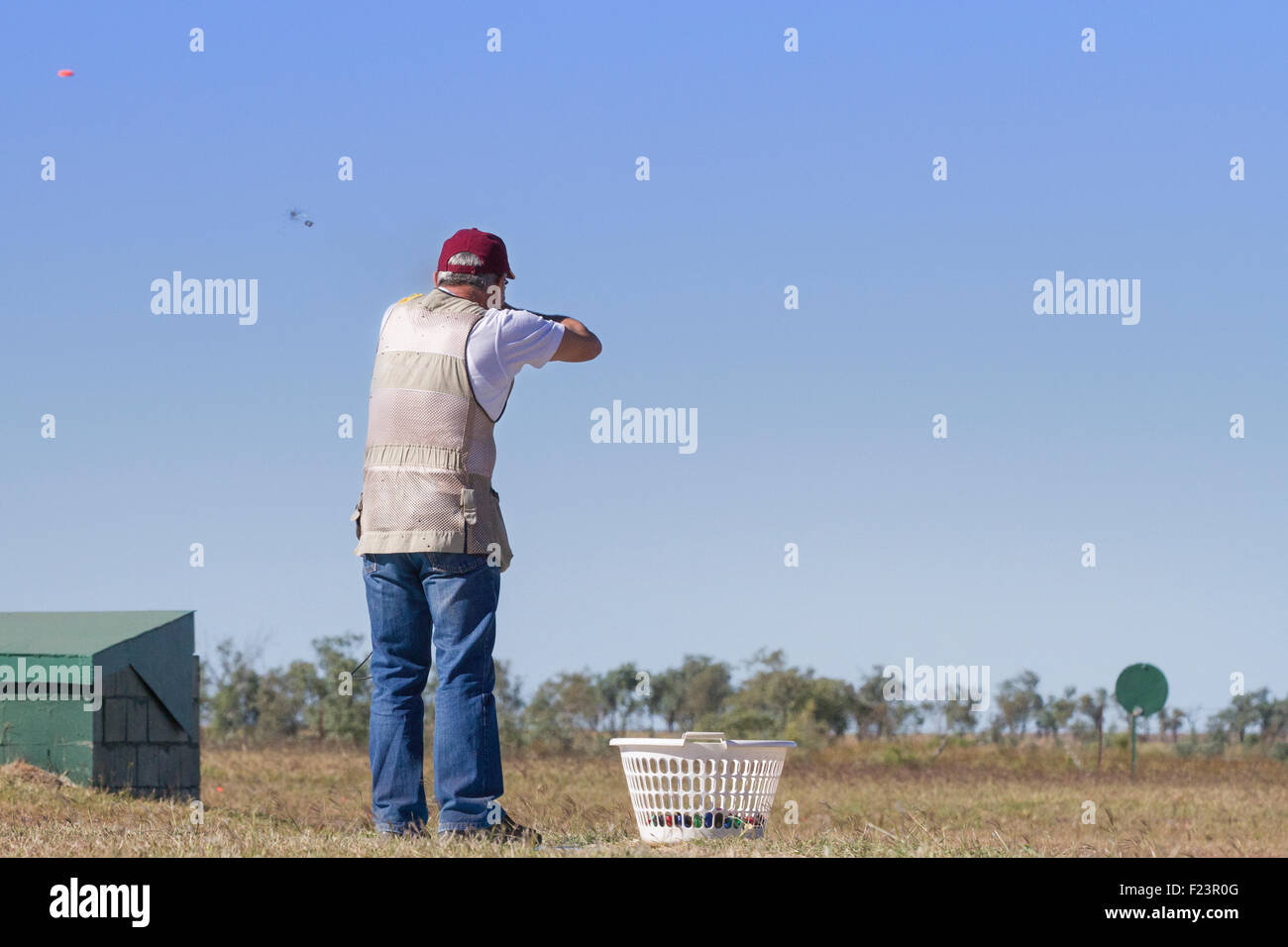 Clay target shooter aiming at the clay target, showing wad and shot