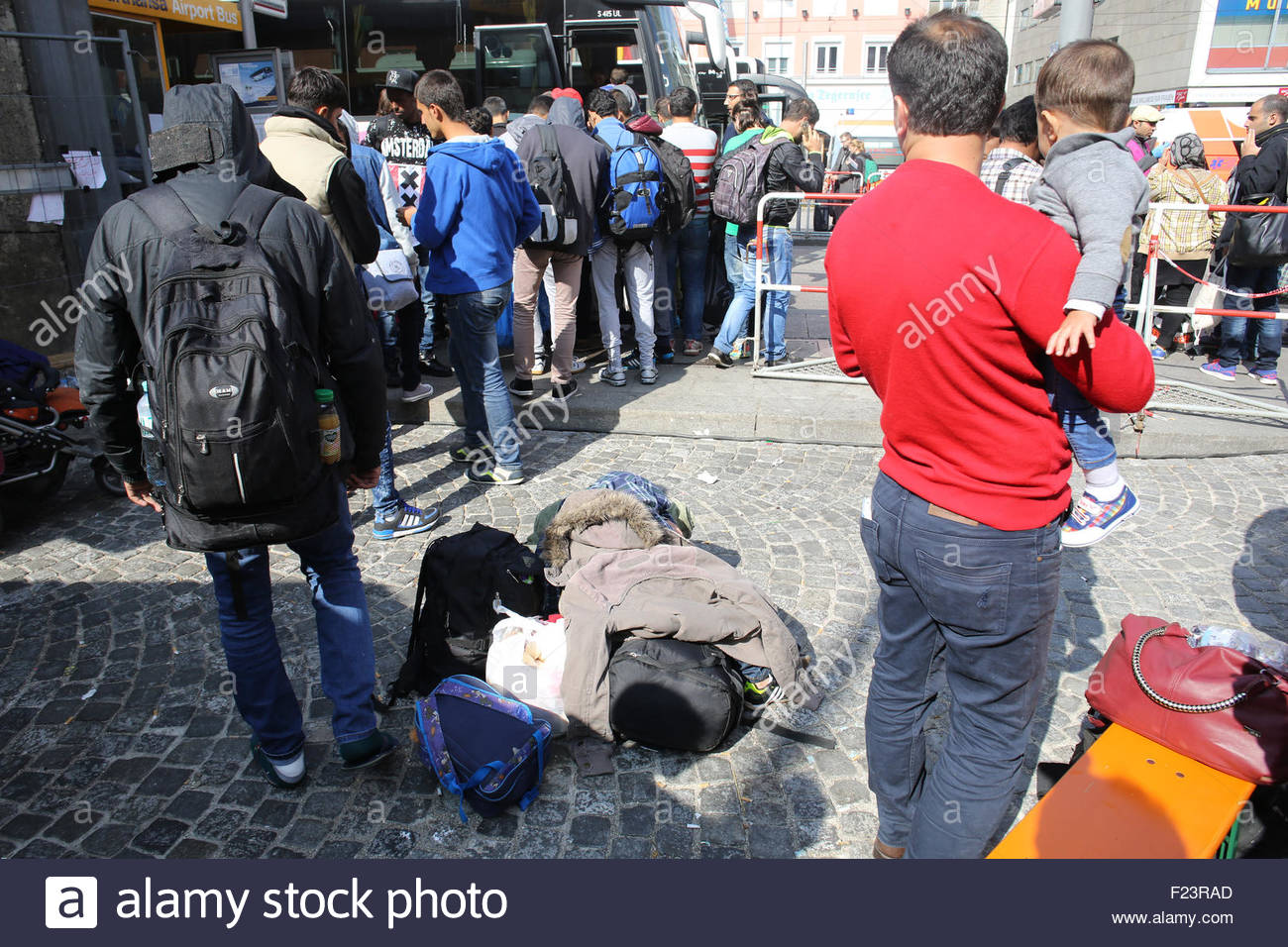 Munich, Germany. 10th September, 2015. A man from Syria holds his child while waiting to be transported from Munich Central Station in Germany.The flow of refugees arriving in Munich continued Thursday, September 10th, as Europe struggles to cope with the flood of people. Credit:  Clearpix/Alamy Live News Stock Photo