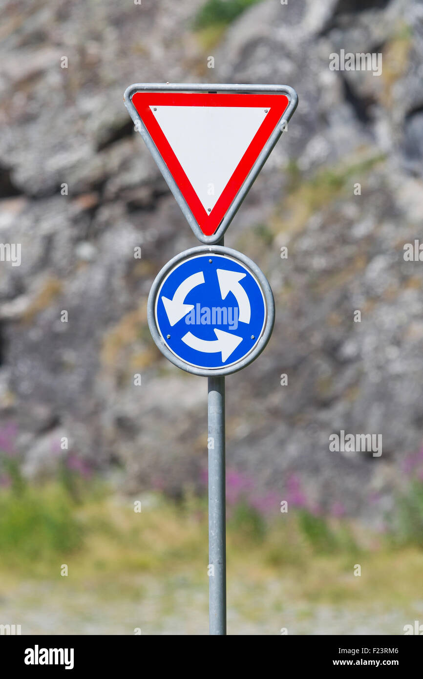 Roundabout crossroad road traffic sign, blue, white arrows right hand Stock Photo