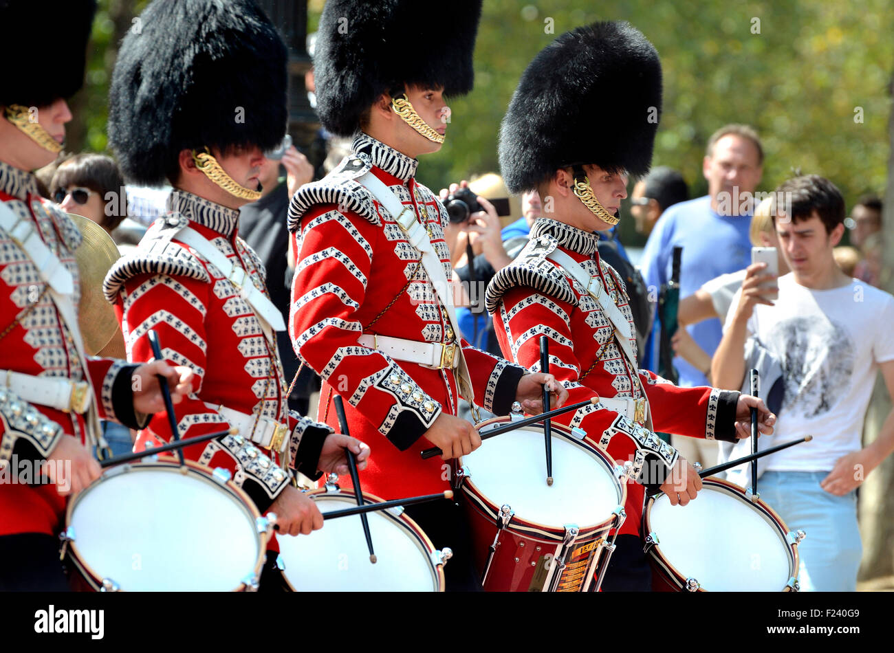 London, England, UK. Guardsmen drumming and marching after the Changing of the Guard - man filming on his mobile phone Stock Photo